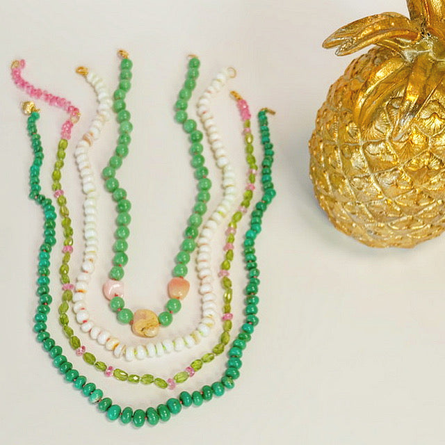Display of 14k gold Chrysoprase candy Necklace layered with other gems