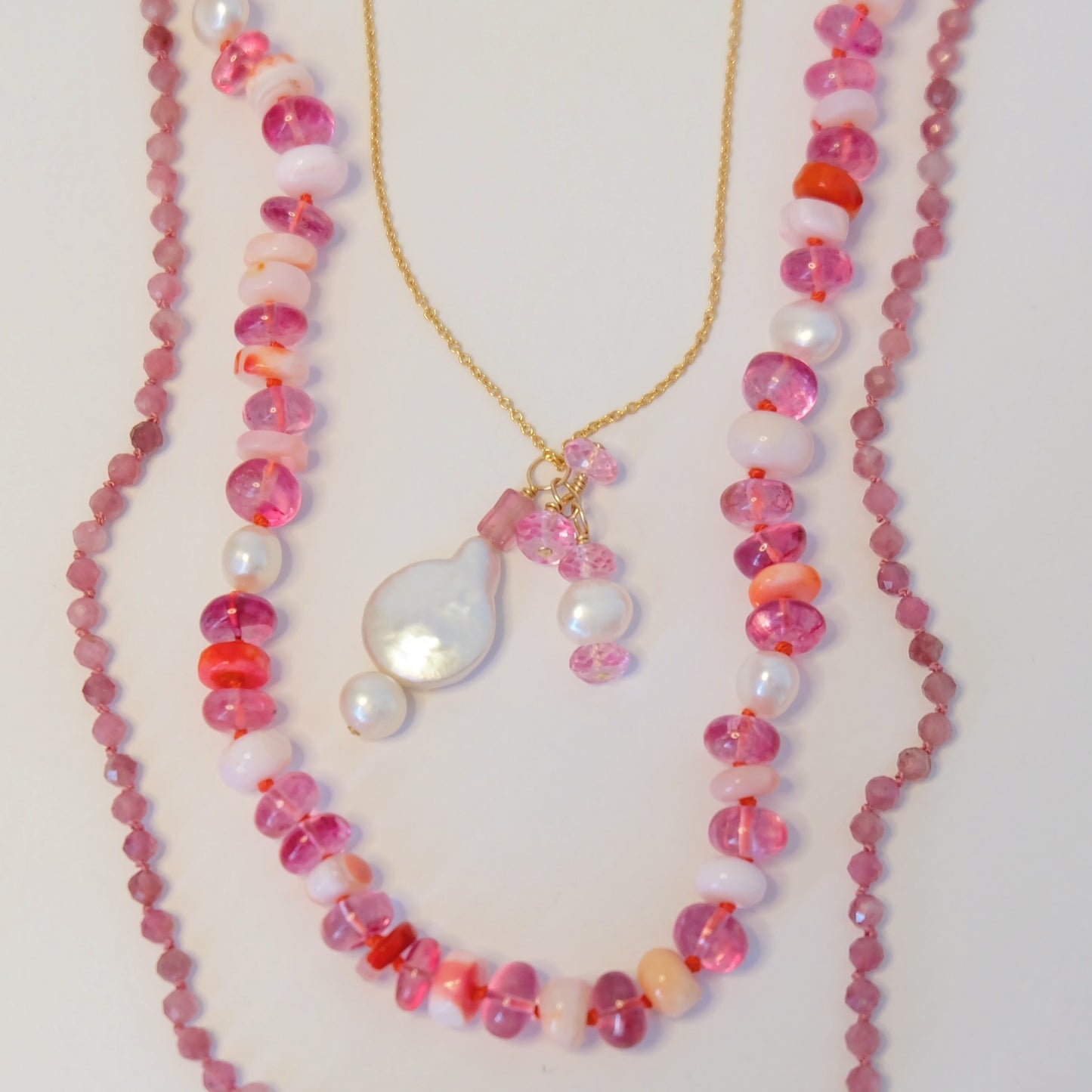 Elegant necklace featuring pink tourmaline and pearl charms, perfect for adding a touch of sophistication to any outfit.