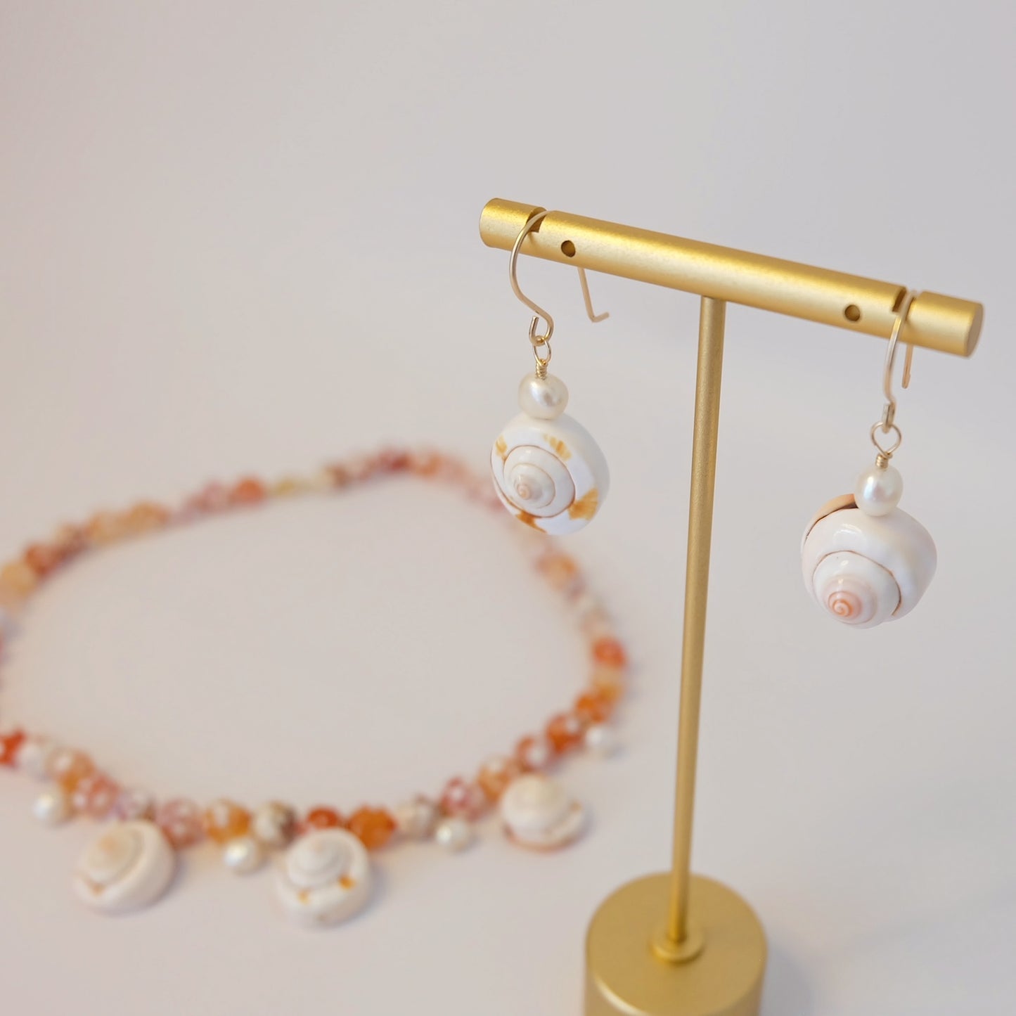 Chic pearl shell earrings designed with a radiant surface, offering a refined accessory for various occasions.