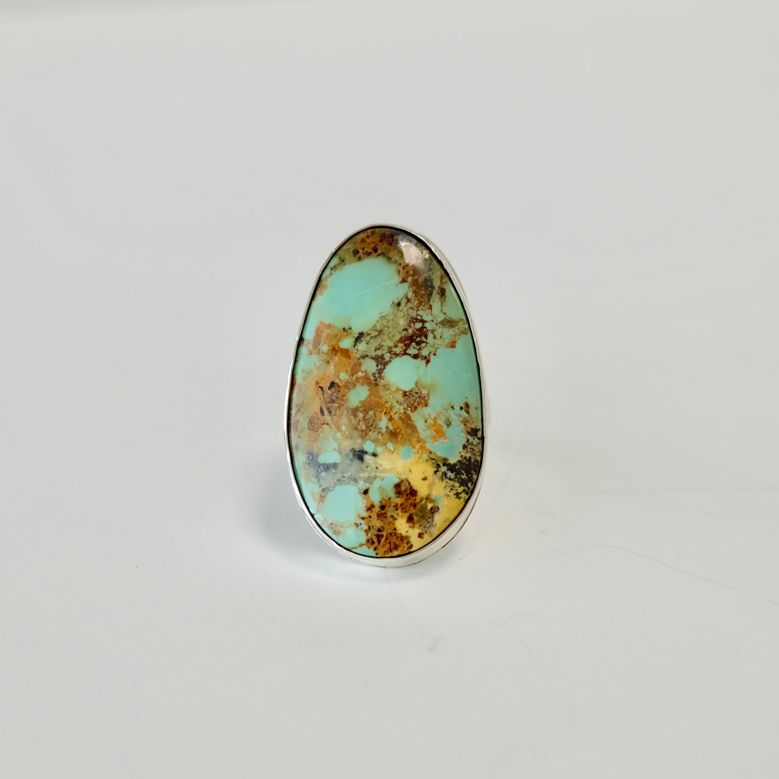 Stella blue turquoise silver ring with brown and black speckles on a white background