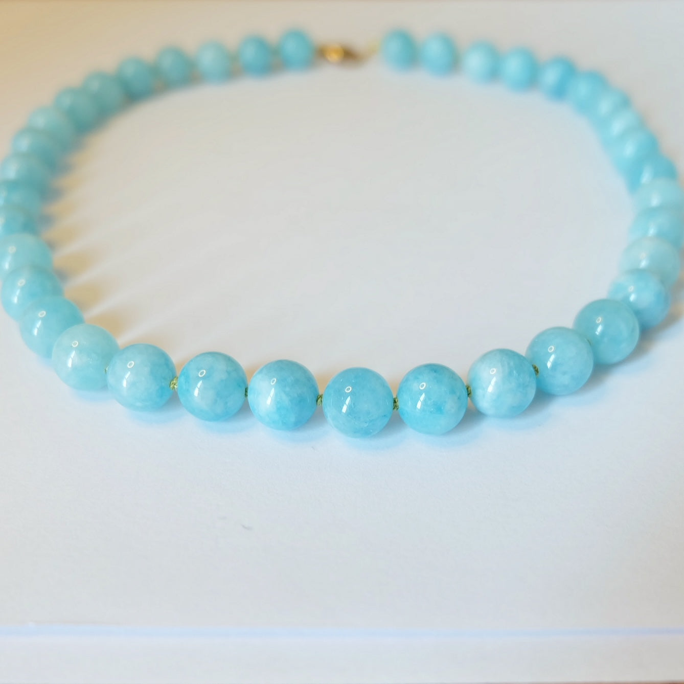 Close-up of the Aquamarine Candy Necklace, highlighting the 10MM aquamarine gumball beads and ethically sourced 14K gold-filled clasp