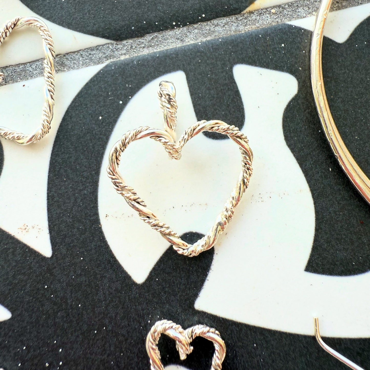 Close up image of braided stering silver heart pendant.