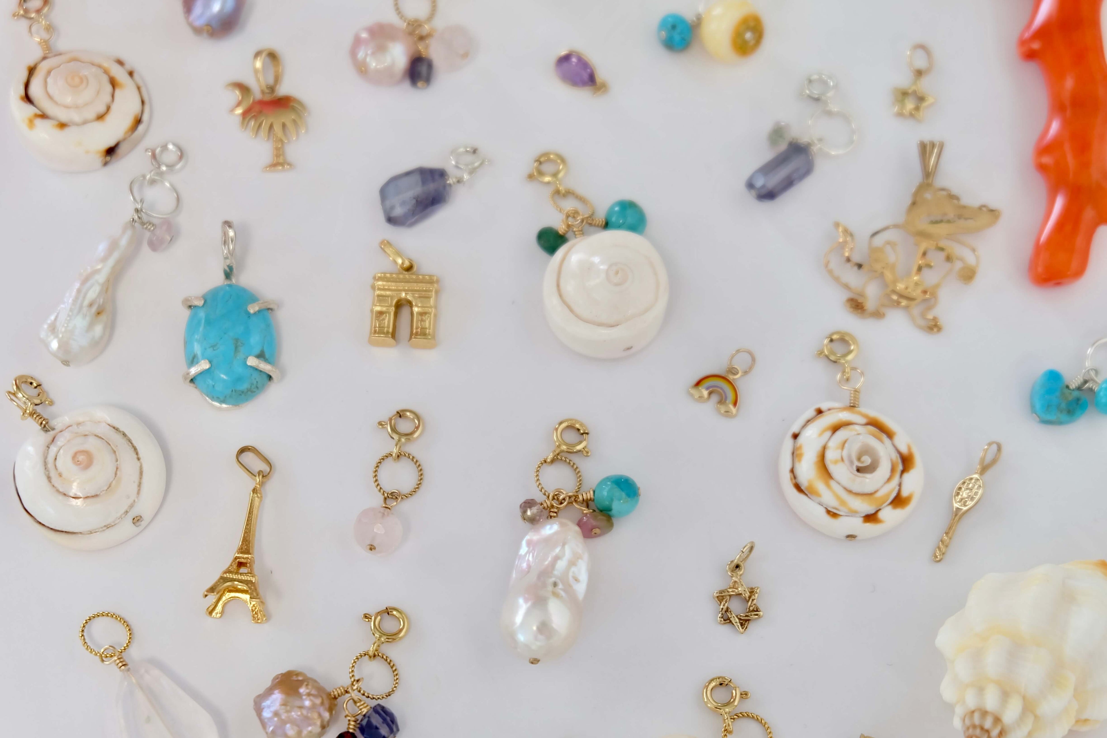 A variety of decorative charms in multiple colors and shapes, artistically laid out against a plain backdrop.