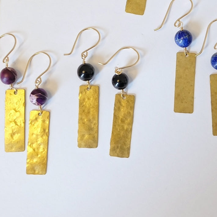 Display of hammered brass earrings with black onyx