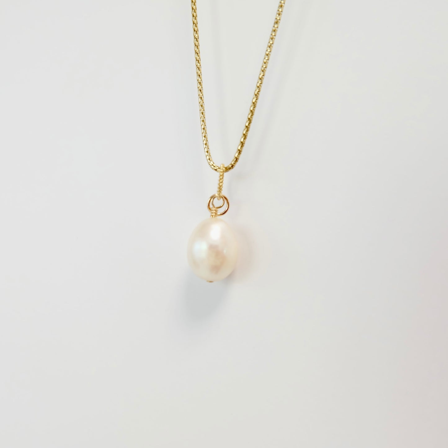Elevate your style with our Pearl Charm, crafted with a lustrous pearl and 14k gold filled wire for added sophistication.