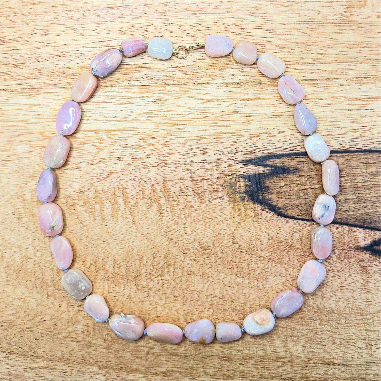A beautiful pink opal bead necklace composed of lustrous beads, ideal for enhancing both casual and formal attire.