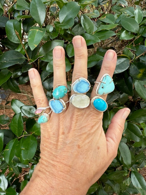 Hand wearing mixed sterling silver rings featuring a lavender turquoise ring from Golden Hills