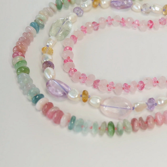 Display of handmade candy necklaces featuring semiprecious gemstones, silk thread, and 14K gold clasps