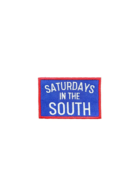 Embroidered patch with 'Saturdays in the South' text on a blue background with red border.