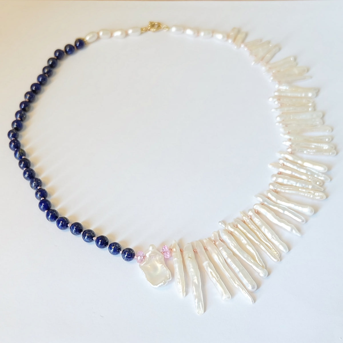 Close-up of lapis lazuli and pink topaz beads on a Biwa pearl necklace