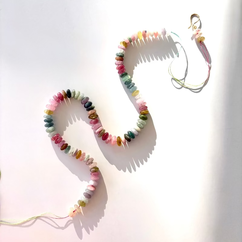 Colorful watermelon tourmaline beaded candy necklace in solid 14K gold on a white background.