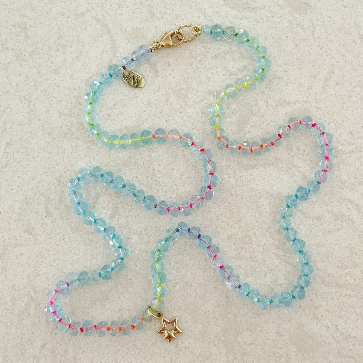 14K gold double star charm worn as a pendant