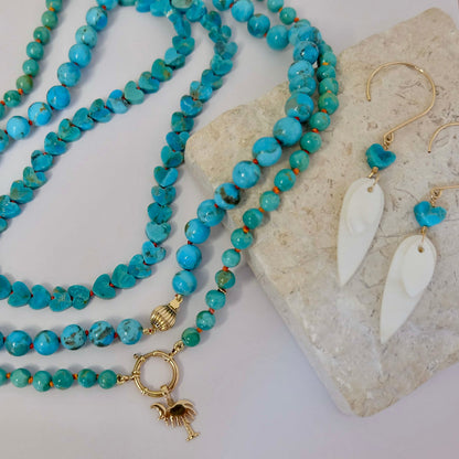 14K gold Kingman turquoise heart necklace styled next to matching turquoise heart drop earrings.