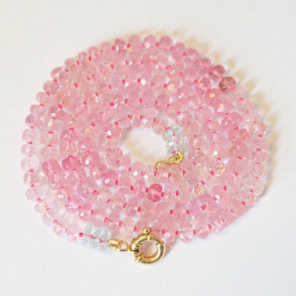 Display of pink tourmaline beaded candy necklace in 14k gold with hand-knotted silk and Burmese gemstones.
