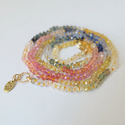 14k gold Rainbow Sapphire candy Necklace featuring hand-knotted pink, blue, green, and yellow sapphires with a 14K gold clasp.