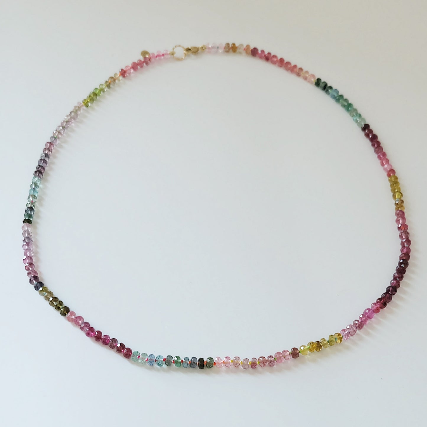 Full view of a 14K gold watermelon tourmaline candy necklace with pink and green gemstones.