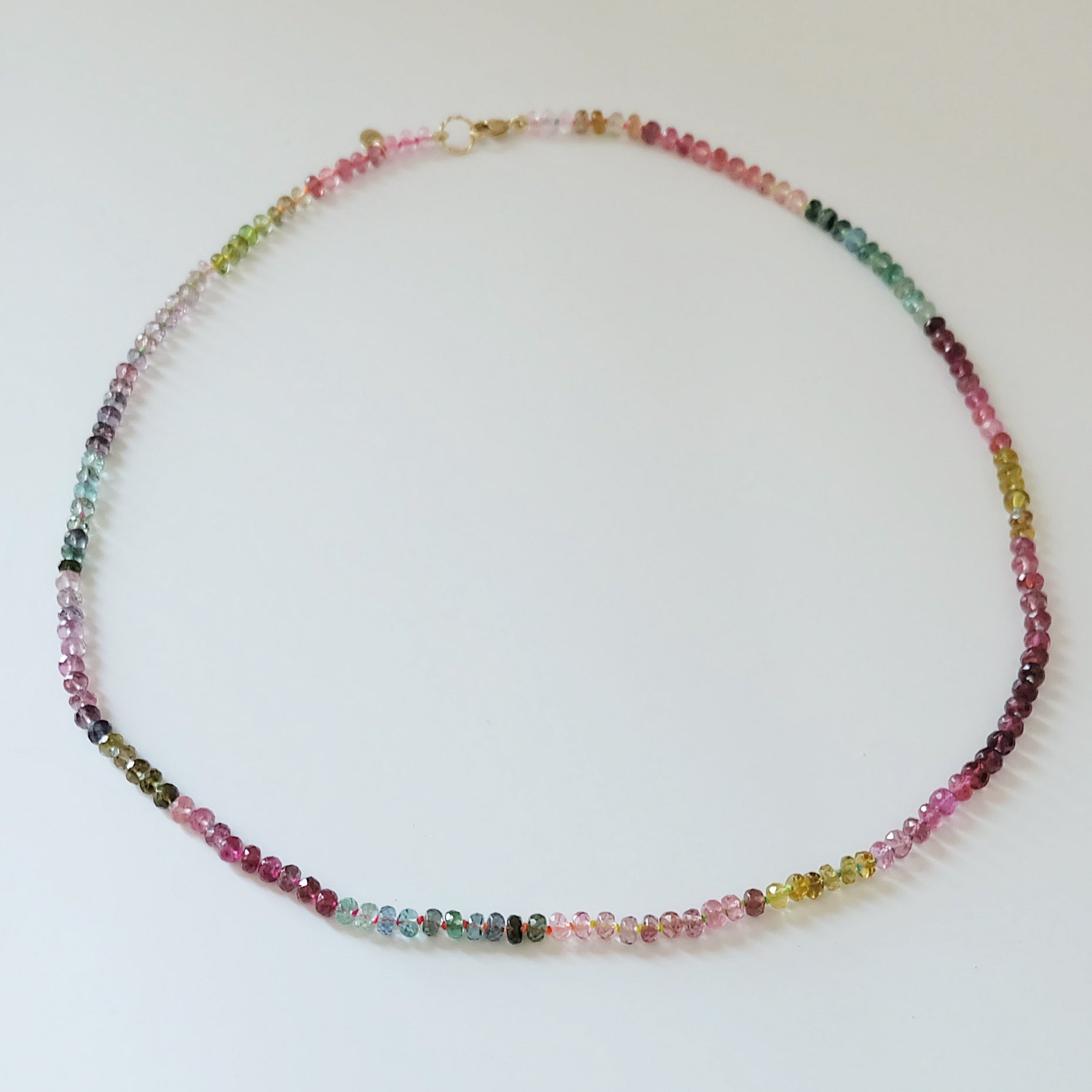 Full view of a 14K gold watermelon tourmaline candy necklace with pink and green gemstones.