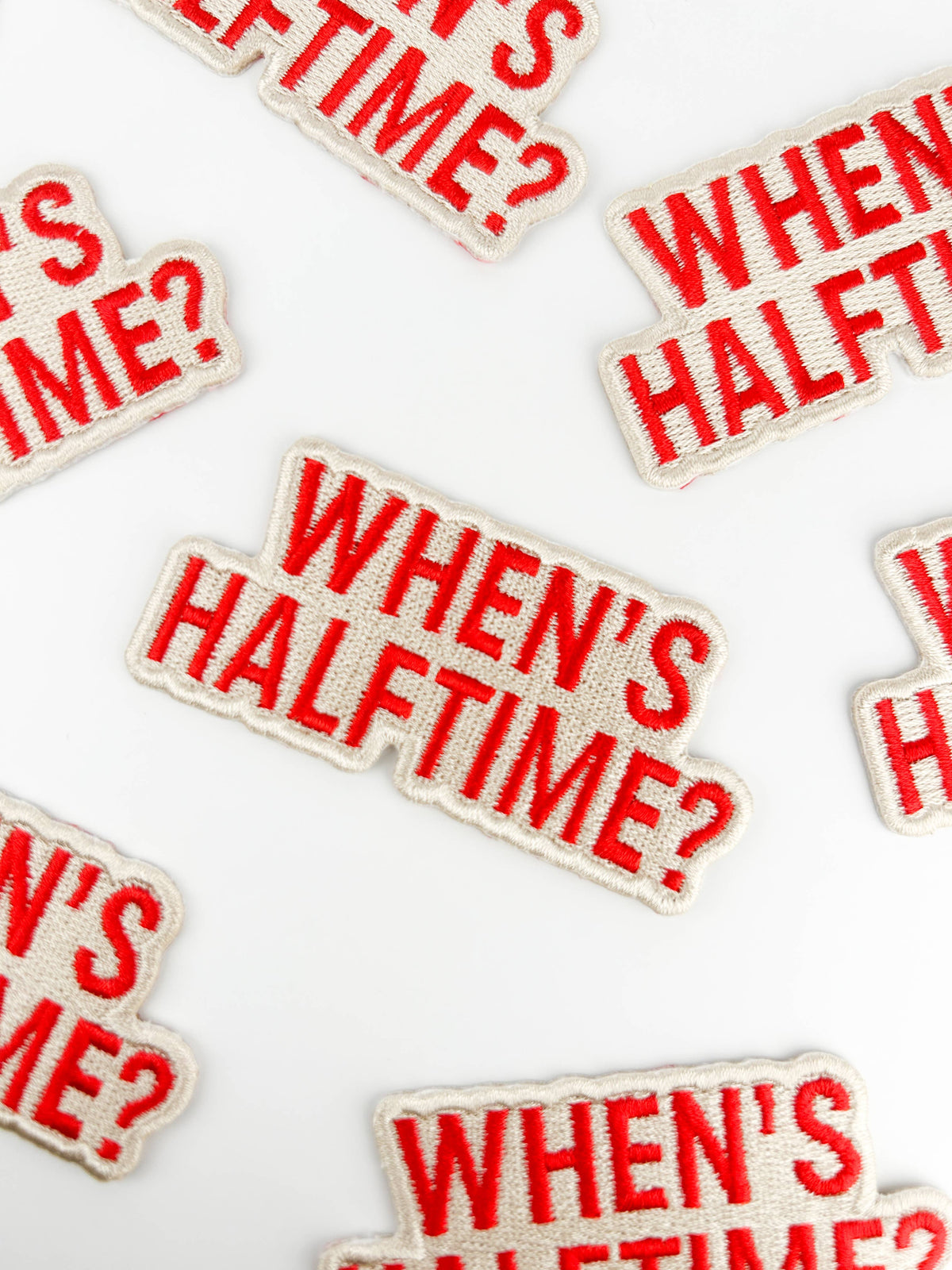 Multiple patches with 'WHEN'S HALFTIME?' text on a white background