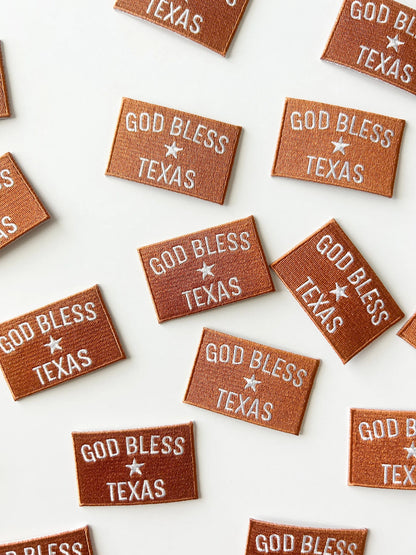 Multiple 'God Bless Texas' patches on a white background