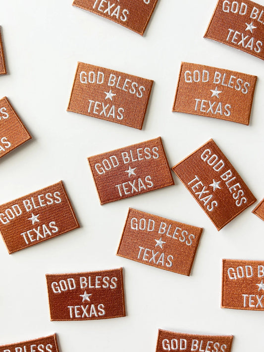 Multiple 'God Bless Texas' patches on a white background