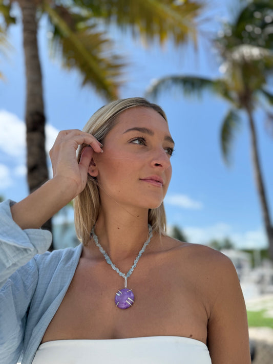 Woman wearing an Aquamarine necklace in sterling silver with sugilite charm.