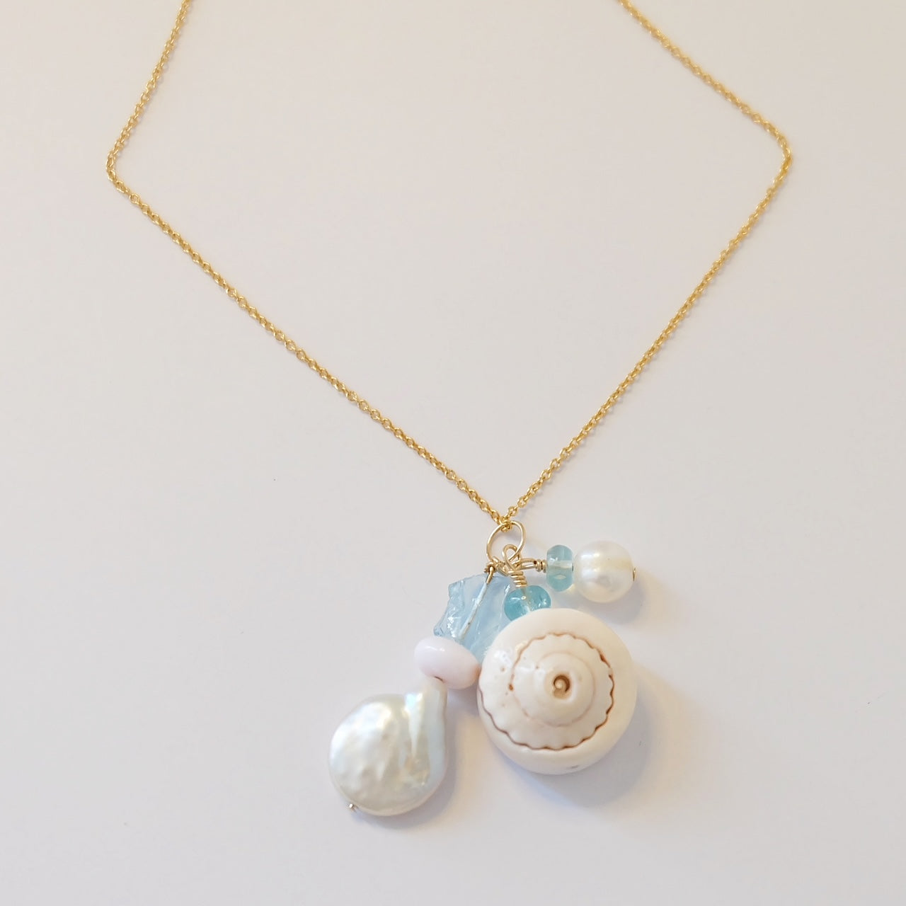  Elegant Aquamarine Pearl Opal Shell Charm Necklace featuring handcrafted charms on a delicate 14K gold filled chain.