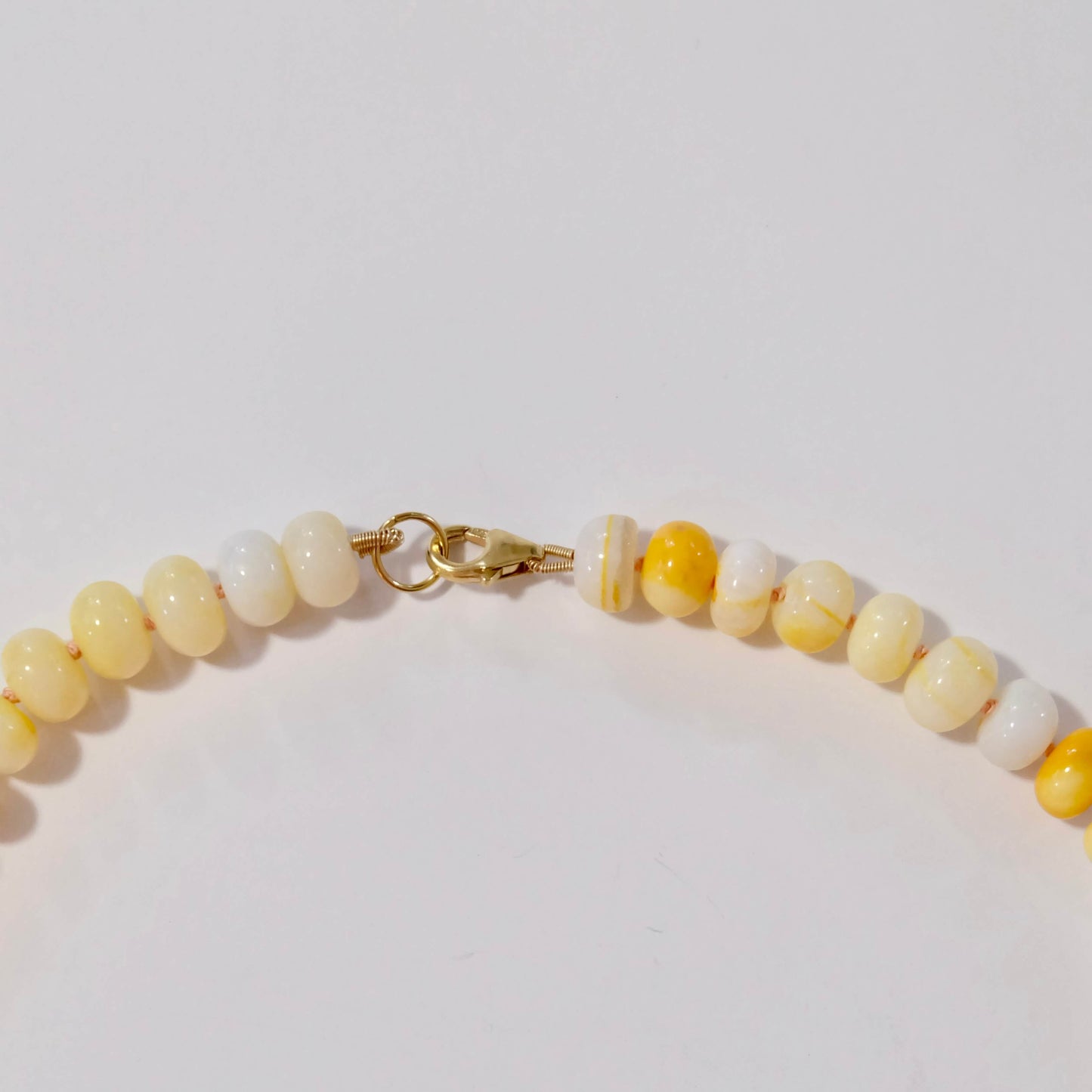 Beaded yellow candy necklace with yellow and white beads on a light background