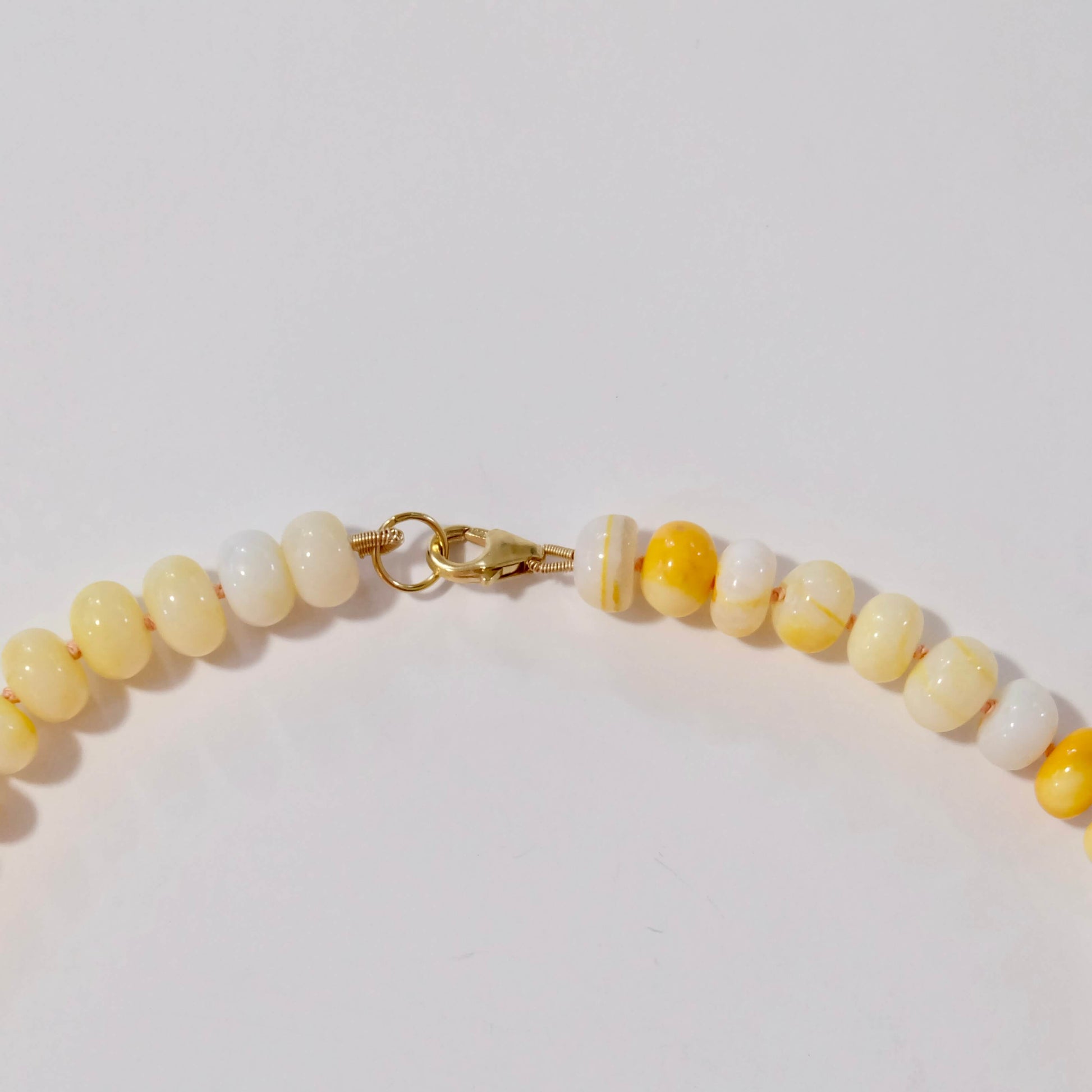 Beaded yellow candy necklace with yellow and white beads on a light background