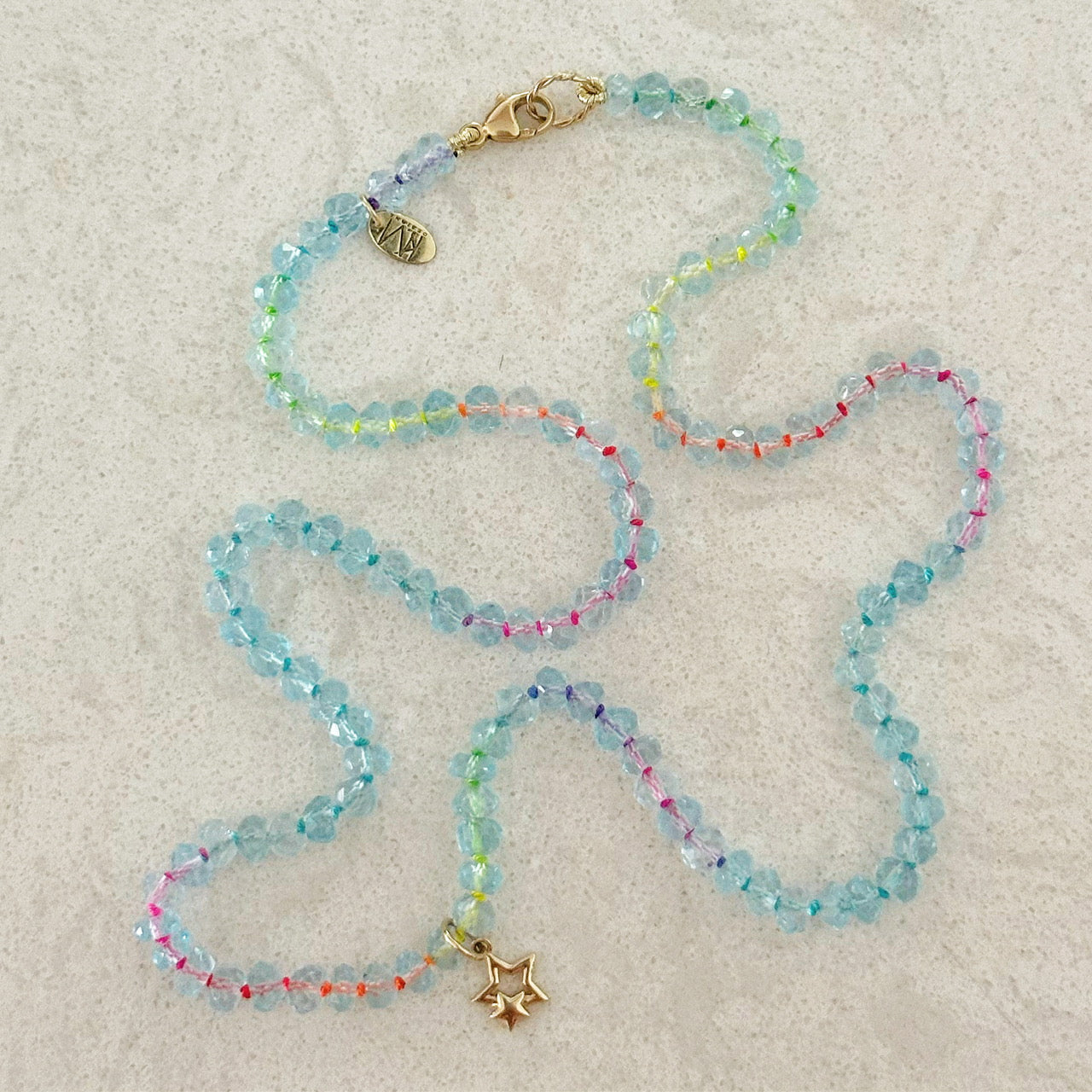 Close-up of aquamarine beads and gold charm