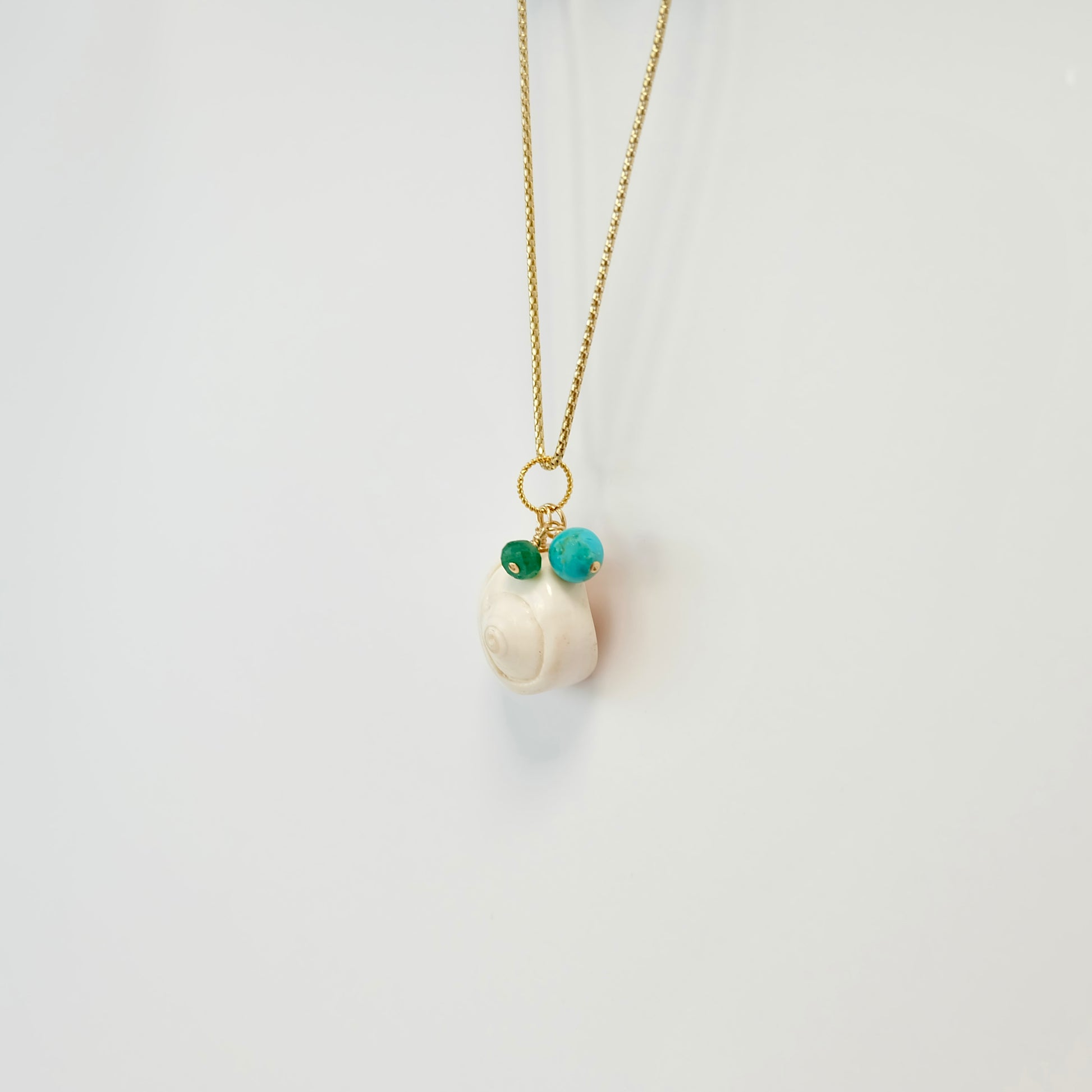 Elegant turquoise sea shell charm with an emerald accent, a delightful addition to any jewelry for a beach-inspired look