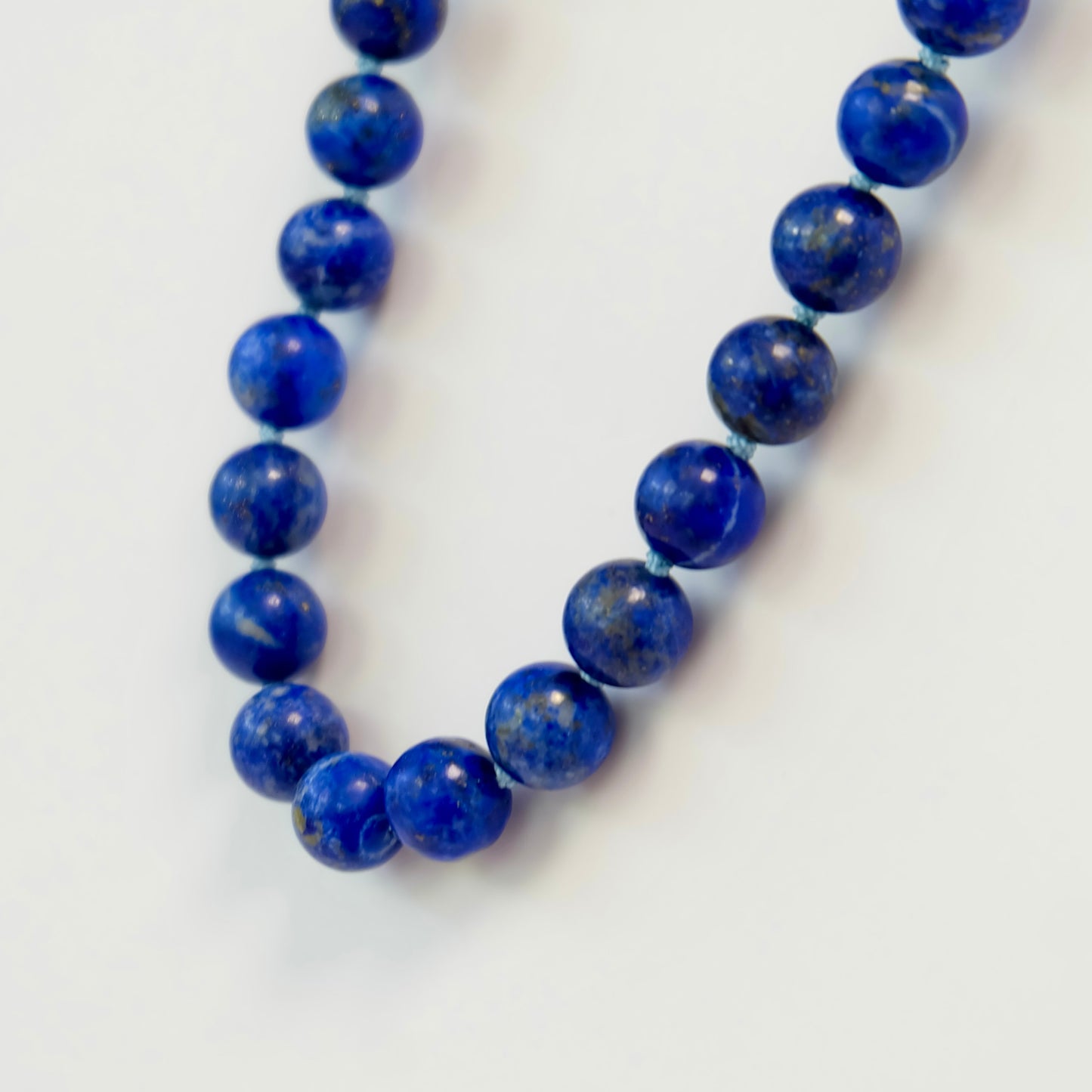 Elegant knotted necklace made of lapis beads, highlighting deep blue tones and a stylish, textured appearance.