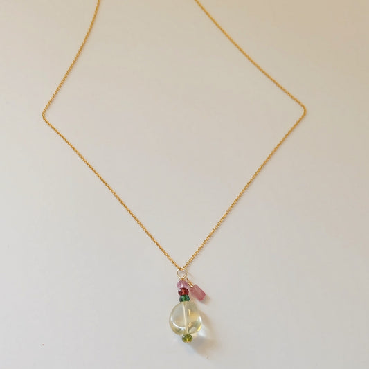 A delicate gold charm necklace featuring green amethyst and tourmaline gemstones, showcasing elegance and sophistication.