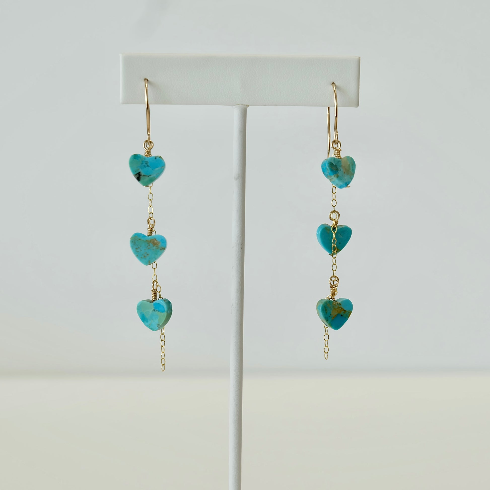 Kingman turquoise heart dangle earrings displayed on white background 