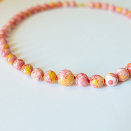 A vibrant orange jasper candy necklace featuring beautifully arranged beaded gemstones, showcasing a striking design.