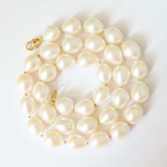 A stunning pearl necklace on rainbow silk thread.