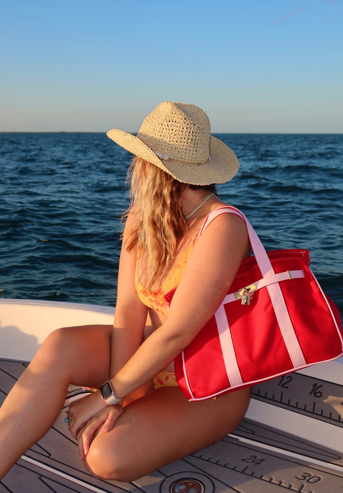 Woman with a reed and pink Boatkin boat tote on a boat