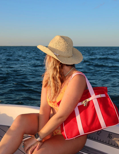 Woman with a reed and pink Boatkin boat tote on a boat