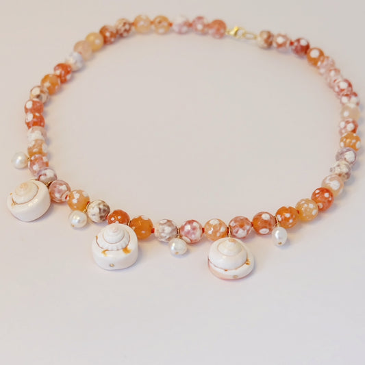 Elegant Pearl Agate Seashell Charm Necklace with unique hand-forged charms, beautifully knotted on silk for a coastal look.