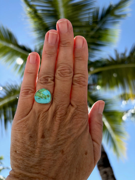 Woman's hand wearing a Sonora gold turquoise ring in 14k gold bezel