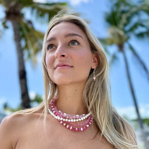 Portrait image of woman wearing a stack of layered necklaces