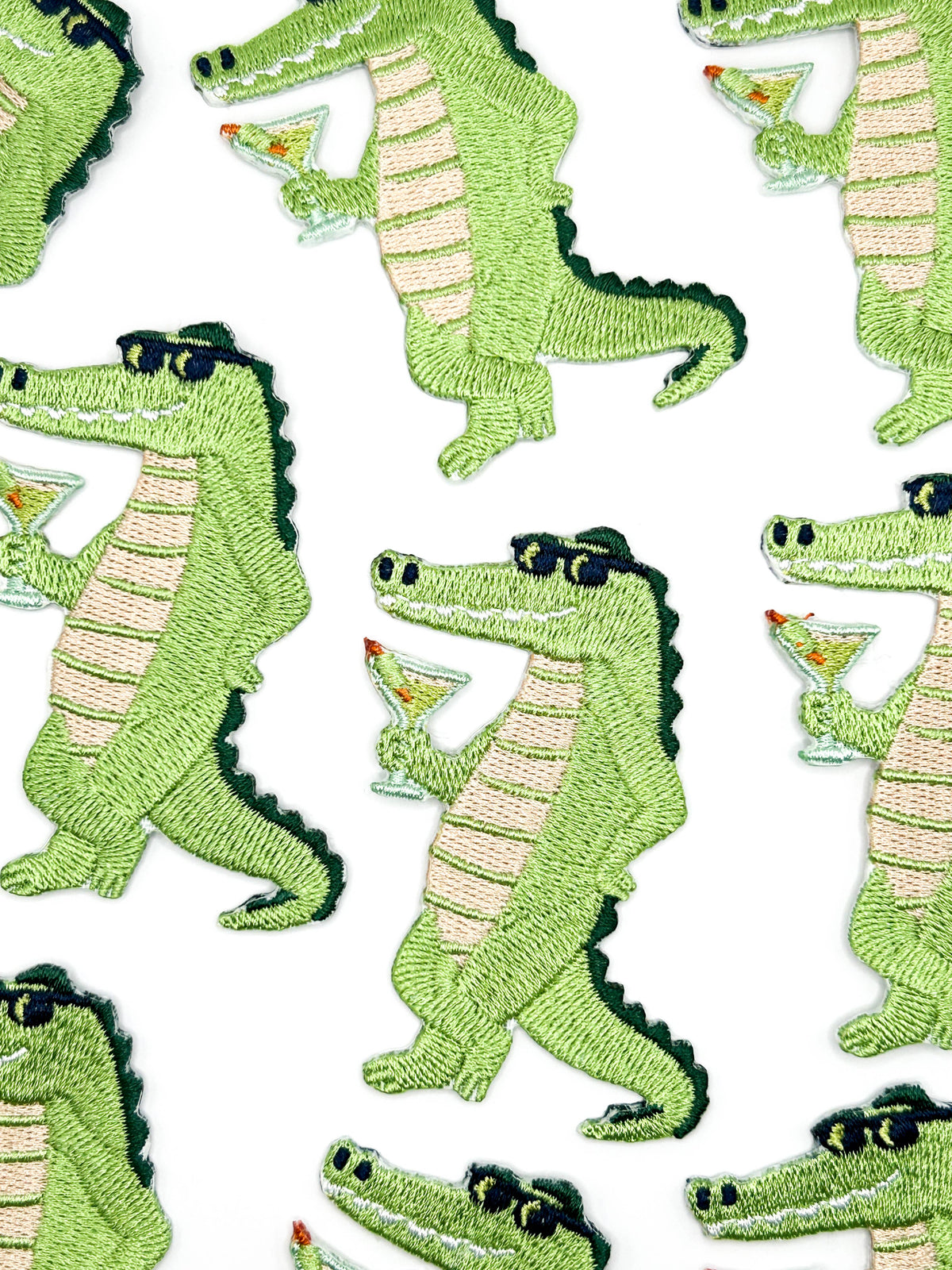 Alligator patch in green with tan belly and black sunglasses holding a cocktail