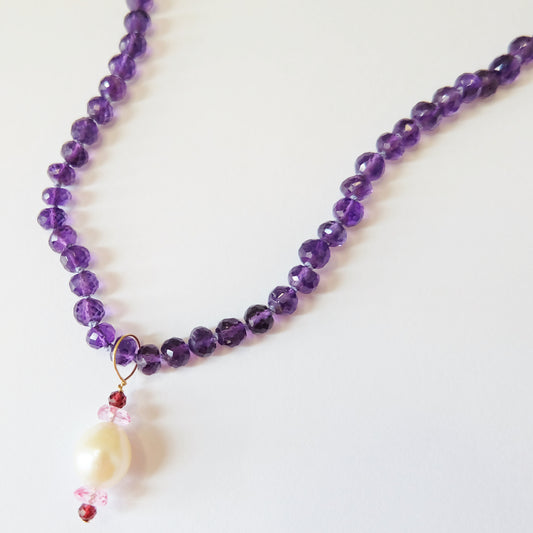 Close-up of amethyst beads and gemstone charms