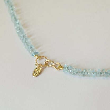 Solid 14K gold S-clasp and brand tag on aquamarine necklace.