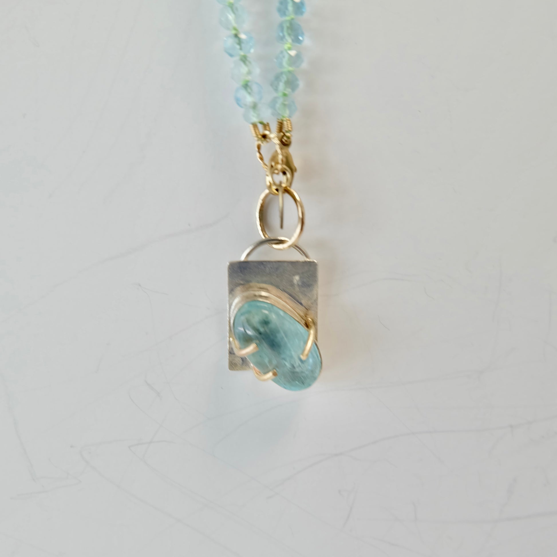 Removable charm detail on the Aquamarine Charm Necklace in 14K gold.