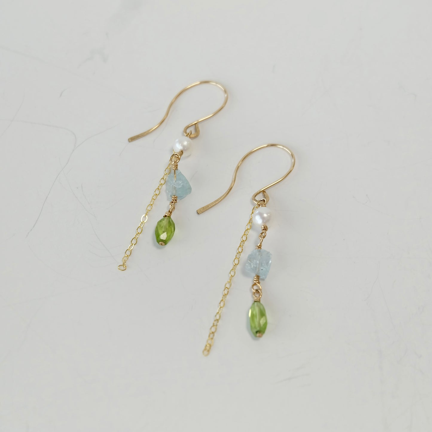 Side view of one-of-a-kind Aquamarine, Peridot & Pearl Dangle Earrings with hand-forged French hooks.