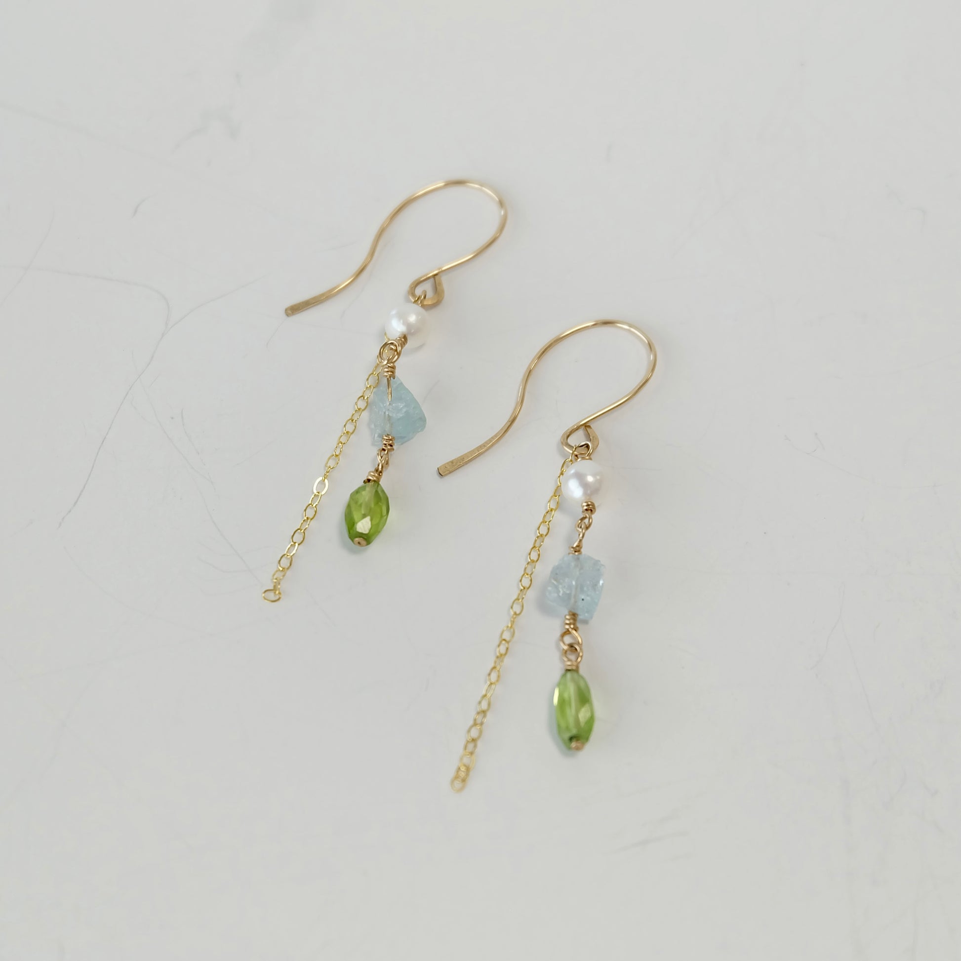 Side view of one-of-a-kind Aquamarine, Peridot & Pearl Dangle Earrings with hand-forged French hooks.