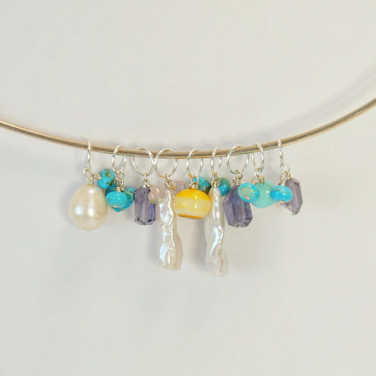 Unique sterling silver charms featuring gemstones, ethically crafted to enhance your jewelry collection with hand-forged designs.