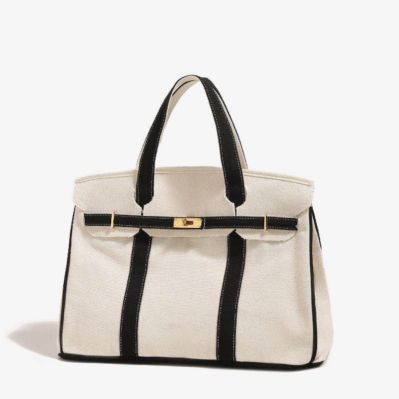 Closed side view of black Boatkin bag with gold hardware on a white background