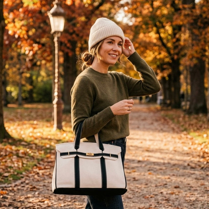 Woman carrying a black trim Boatkin bag in a park in the in fall.