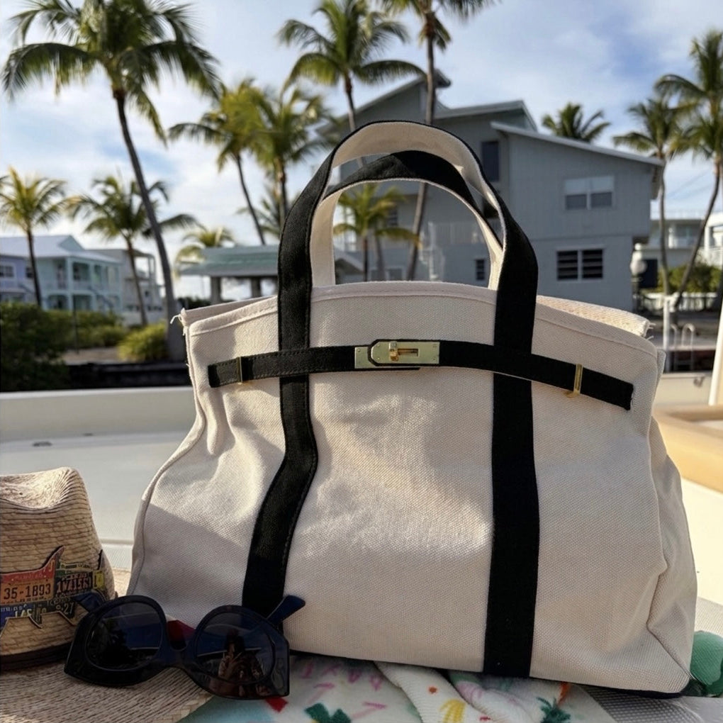 Black Boatkin bag on a boat deck with palm trees and houses in the background.